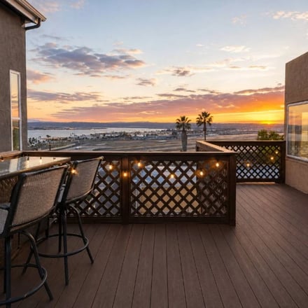 Rooftop deck with bar seating overlooking San Diego Bay at sunset