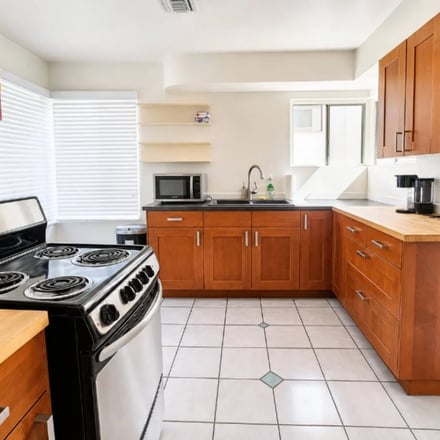Little Italy 4BR full kitchen with warm wood cabinets and butcher-block island