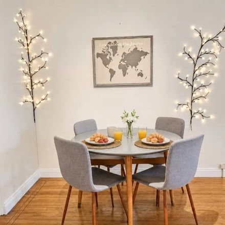 Little Italy dining nook with round table, fairy-light branches and hardwood floors