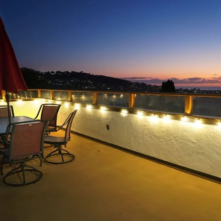 Lit rooftop deck at night overlooking La Jolla