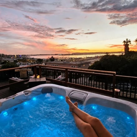 Hot Tub Skyline Deck blue-lit hot tub with San Diego skyline and bay at dusk